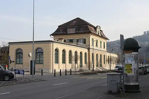 Yellow one-story building with three-story center tower