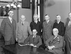 Members of Reid's cabinet gathered around a table in an office.