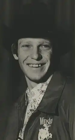 Black-and-white portrait of Roy Cooper at age 21. He then was a young, clean-shaven white man wearing a suit and tophat.