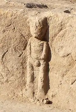 Central figure, with V-shaped collar clearly visible