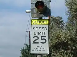 A school zone sign in the United States. When the light flashes, the set speed limit (in this case, 25 mph (40 km/h)) is active.