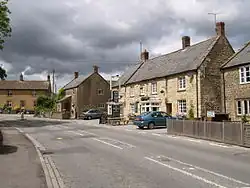 Street scene with a row of detached houses including a pub.