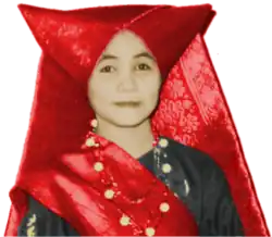 A woman wears a Minang tengkuluk tanduk horned head-dress.