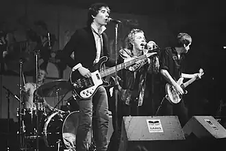 Members of rock band the Sex Pistols onstage in a concert.