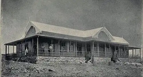 Workers standing on the veranda of a Dutch-style building