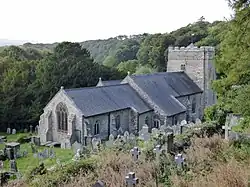 a church with a square tower in a churchyard