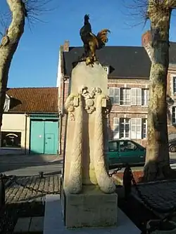 The garlanded war memorial at St Riquier