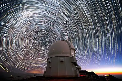 This image shows stars appearing to "trail" around the south celestial pole (at the center of the circles) above the Southern Astrophysical Research Telescope