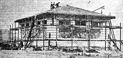 A low stone building under construction