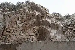 Details of a ruined stone structure covered by grass
