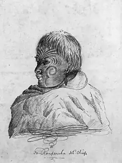 a pencil sketch of the head and shoulders of a man with tribal tattoos on his face. A cloak covers his shoulders