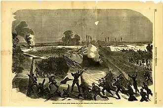Ranks of soldiers charging over an embankment; one soldiers in the foreground carries the United States flag. A bridge burns in the distance, with fleeing soldiers in the background