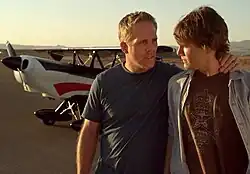 Reiley McClendon and Ed Thomas reprise their roles, standing at an airport during a test-scene for The Flyboys television project.