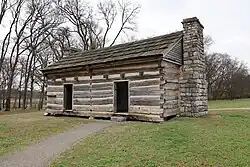 Two-door wooden cabin with stone fireplace and no windows