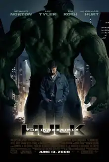 Bruce Banner (Edward Norton) stands with the Hulk facing back, in a city landscape with tanks on the road and helicopters hovering in the sky with spotlights.