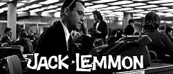 Black-and-white film still from the trailer showing the upper part of the profile of a white man in a suit at a desk looking at a desktop calculator. The letters "JACK LEMMON" in white are imposed on the still. In the background, there are other white office workers, both men and women. The low point of view allows to see the rectangular light panels extending all over the room ceiling.