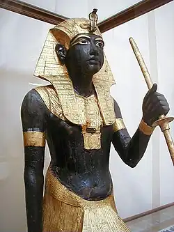 Gilded statue wearing a headdress with a model cobra