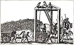 A monochrome illustration of a three-legged structure, with beams connecting each leg along the top (forming an equilateral triangle, on its side). Several men are sitting at the top of the structure, near a ladder, about 20 feet above the people below. A rope connects the top of the structure to the neck of a man, stood on a horsecart. Another man is reading from a book, in his direction. Horses pull another cart, on which two coffins can be seen. A large crowd is gathered on the horizon, watching the scene.
