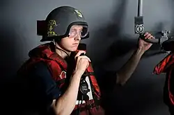 A sailor using a sound-powered telephone while wearing a Mark 4 talker helmet aboard the USS George Washington (CVN-73) in 2011