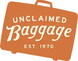 A silhouette of a suitcase with the text "Unclaimed Baggage, Est. 1970"
