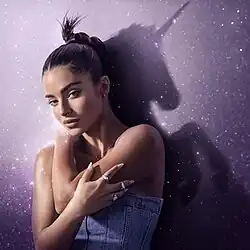 The official cover for "Unicorn". The cover features Noa Kirel amongst a pink background. Kirel's shadow behind her displays a silhouette of a unicorn.