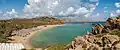Panorama of Vai beach from the southern headland showing the roof of the restaurant, the sun shelters, the northern headland and pigeon rocks.