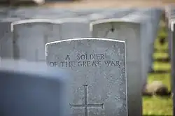 Tombstone of an unknown soldier at Tyne Cot Cemetery. The inscription uses Gill's Headstone Standard Alphabet.[7]