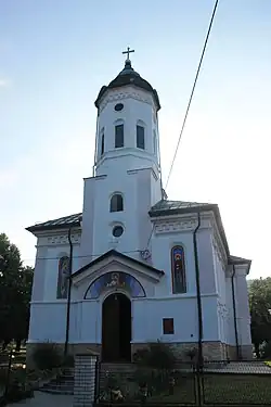 The front of a small white church. Picture taken from street level.