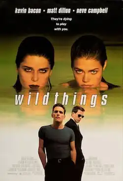 Two women, their heads just above water, staring intently. Two men stand in the foreground.