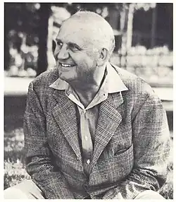 William M. "Skipper" Beals seated in front of the original Homestead Building on the campus of Leelanau for Boys in around 1940.