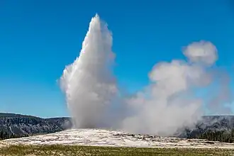 Water ejecting from the ground and steam rising to the right