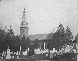 Black and white photograph of a church with a cemetery in the foreground