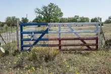 A farm gate painted to look like the Texas flag.