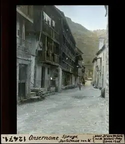 An old, colorized photograph of Spruga from 1940 with handwritten notes at bottom in German